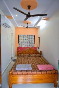 a bedroom with a wooden bed with a ceiling fan at Sri Dattatreya Nivas in Pithāpuram