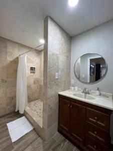 a bathroom with a sink and a shower with a mirror at Divine Casita in Del Rio +14 photos