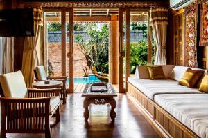 salon z kanapą i stołem w obiekcie Santhiya Phuket Natai Resort & Spa w mieście Natai Beach +150 zdjęć