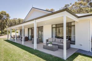 una casa con un portico con un divano e finestre di Wildgreen Villa - Lakeside Hideaway in Winery Estate a Yallingup Siding