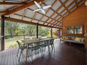 einen Holztisch und Stühle auf einer Veranda mit einem Deckenventilator in der Unterkunft Woodland Retreat - Nature Lovers' Ultimate Escape in Margaret River Town