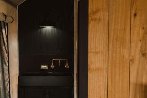 a black room with a purse and a light at Wandagar Eco Tent - Baudin in Pemberton +37 photos