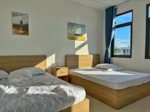 a bedroom with two beds and a window at LIÊM PHẠM MOTEL - Cách cảng 400m in Rach Gia