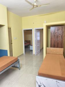 ein Schlafzimmer mit zwei Betten und einem Deckenventilator in der Unterkunft Vybe Hostel in Bangalore