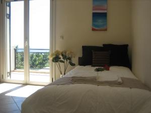 um quarto com uma cama com uma janela e flores em Seapine Studios em Lassi