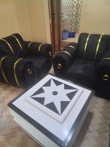 a living room with two black chairs and a table at Keroka Luxury Apartment in Keroka