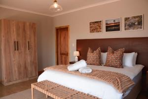 a bedroom with a large bed with a wooden headboard at Leeuwkuil Lodge in Philipstown +7 photos