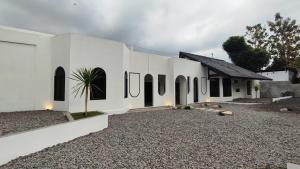 a white house with black windows and a courtyard at Patria Villa Kayen with Private Pool in Yogyakarta