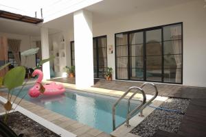 a swimming pool with a pink flamingo in a house at Patria Villa Kayen with Private Pool in Yogyakarta