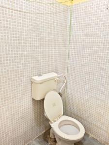 ein Bad mit einem WC in einer gefliesten Wand in der Unterkunft Vybe Hostel in Bangalore