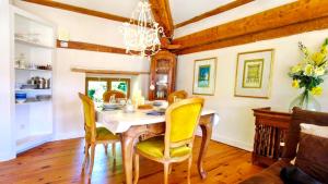 a dining room with a table and yellow chairs at Romantic Village School with Sunny Garden in Le Monestier