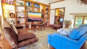 a living room with a blue couch and a tv at Romantic Village School with Sunny Garden in Le Monestier