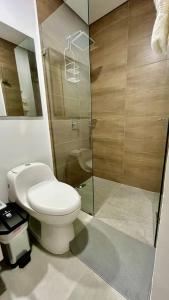 Un baño con inodoro y ducha de cristal. en Samaia Loft, en Santa Marta