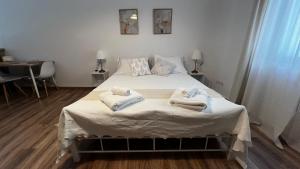 a bedroom with a bed with towels on it at Cloud9 Airport Suites in Koropi