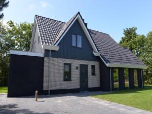 a black house with a black roof at Villa in Texel near Beach and Nature Reserve in Westermient