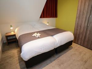 a bedroom with a large bed with two teddy bears on it at Villa in Texel near Beach and Nature Reserve in Westermient