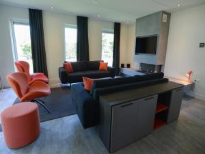 a living room with a couch and chairs and a tv at Villa in Texel near Beach and Nature Reserve in Westermient