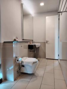 a bathroom with a toilet and a sink and a mirror at Swiss garden residence in Kuala Lumpur