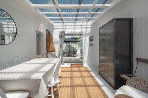 a dining room with a white table and a blue ceiling at Quintessential Russell Cottage in Russell