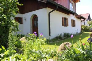 une maison avec un jardin en face dans l'établissement Ferienwohnung Fuchsbau, à Peiting