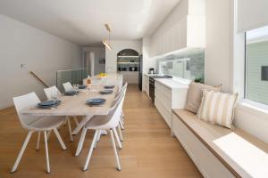 a kitchen and dining room with a table and chairs at The Tropic - Dicky Beach Escape in Caloundra