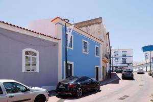a black car parked in front of a blue building at Lagoa Vacation Home in Lagoa