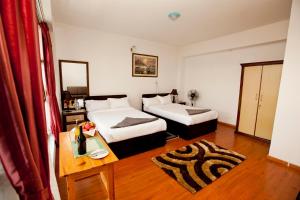 a hotel room with two beds and a table at The Boudha Inn in Kathmandu