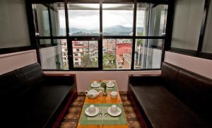 a restaurant with a table and chairs and a large window at The Boudha Inn in Kathmandu