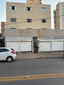 a white car parked in front of a building at Studio 01 térreo in Goiânia