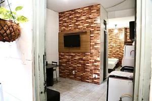 a room with a brick wall with a television on it at Studio 01 térreo in Goiânia
