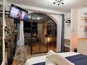 a living room with a sliding glass door with a tv at Luminous French Arch Room in Chuburná de Hidalgo