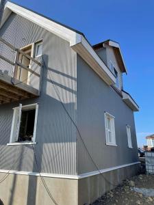 a gray house with a balcony on the side of it at Bjarg in Þórshöfn