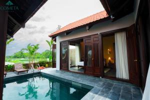 a villa with a swimming pool next to a house at Cometa Villas Ninh Binh in Ninh Binh
