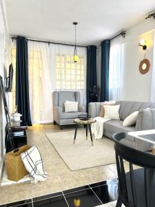 a living room with a couch and a table at Dovy 1br Milimani with AC in Kisumu