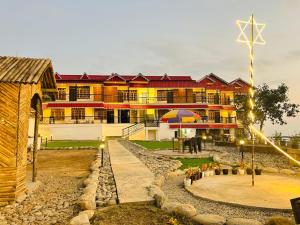 un gran edificio con una sombrilla delante de él en Resort Abhirup, Jhandi, Kalimpong, en Kalimpong
