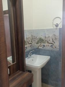 Un baño con un lavabo y un cuadro en la pared. en Resort Abhirup, Jhandi, Kalimpong, en Kalimpong