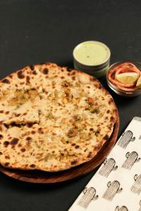 a pizza sitting on top of a table at HOTEL S R Palace - Free Airport Drop for Minimum 05 Nights Stay - 5 mins from IGI & Domestic Airport Delhi in New Delhi