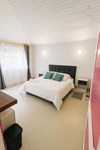 a bedroom with a large white bed with blue pillows at Casa Cocora in Bogotá