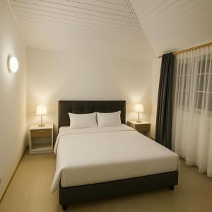 a bedroom with a large white bed with two lamps at Casa Cocora in Bogotá +34 photos