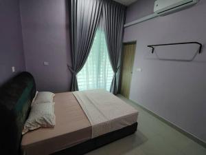 a bedroom with a large bed with a window at Singgah homestay 2 in Sitiawan