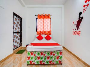 a bedroom with a bed with red pillows at Hotel O RJ Hotel in Nagpur