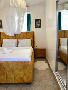 a bedroom with a large bed and a mirror at Dovy 1br Milimani with AC in Kisumu