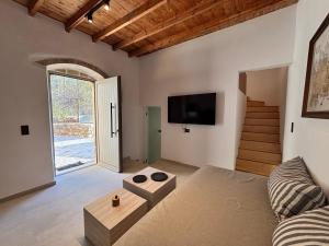 Una sala de estar con un sofá y un televisor. en Aethon Retreat, en Kousés