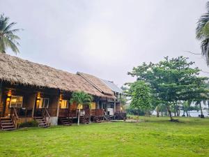 a house with a grass roof and a grass yard at Anaya Beach Resort - Siargao in General Luna