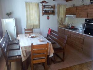 a kitchen with a table with chairs and a refrigerator at Cabana Ninel in Văliug