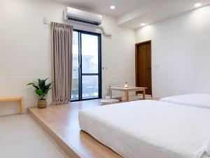 a white bedroom with a bed and a window at 青日所 Midoriya in Tainan