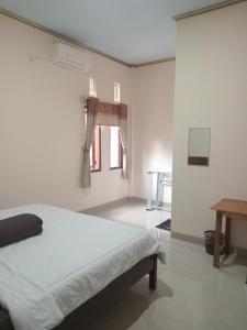 a white bedroom with a bed and a window at PENDIK Home Stay in Labuan Bajo +19 photos