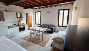 a kitchen and living room with a table and a couch at Affitti Brevi Casaloldo Centro in Casaloldo