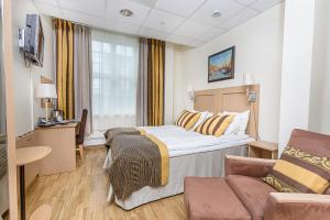 a hotel room with a bed and a couch at Hotell Vic Porsgrunn in Porsgrunn