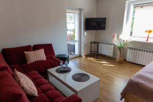 a living room with a red couch and a table at Apartament Wypoczynkowy Tuchola in Tuchola